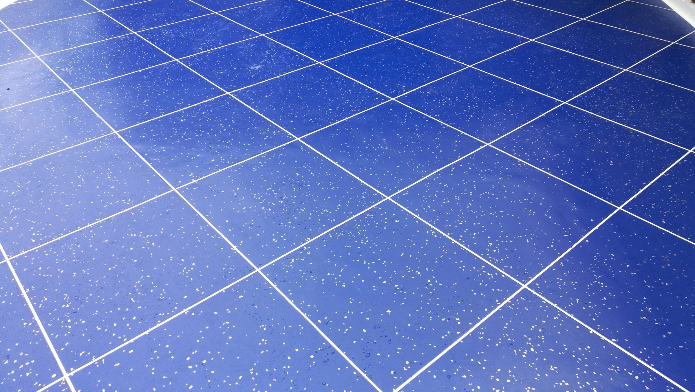 Close-up of a glossy blue tile-effect resin finish with white flecks