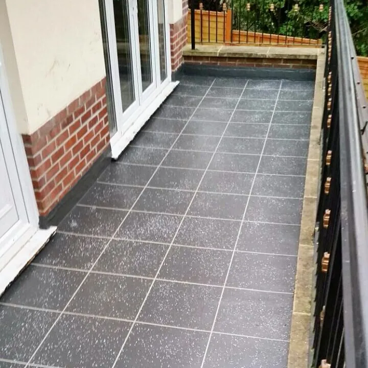 Speckled grey tile-effect balcony with French doors and a black metal railing