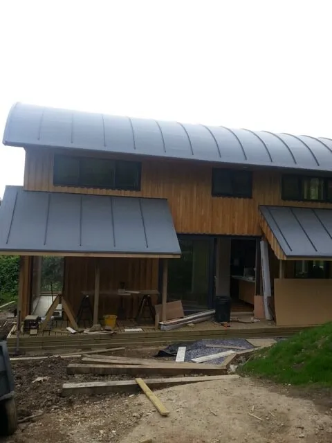 Curved barrel roof on a new timber-clad house during construction