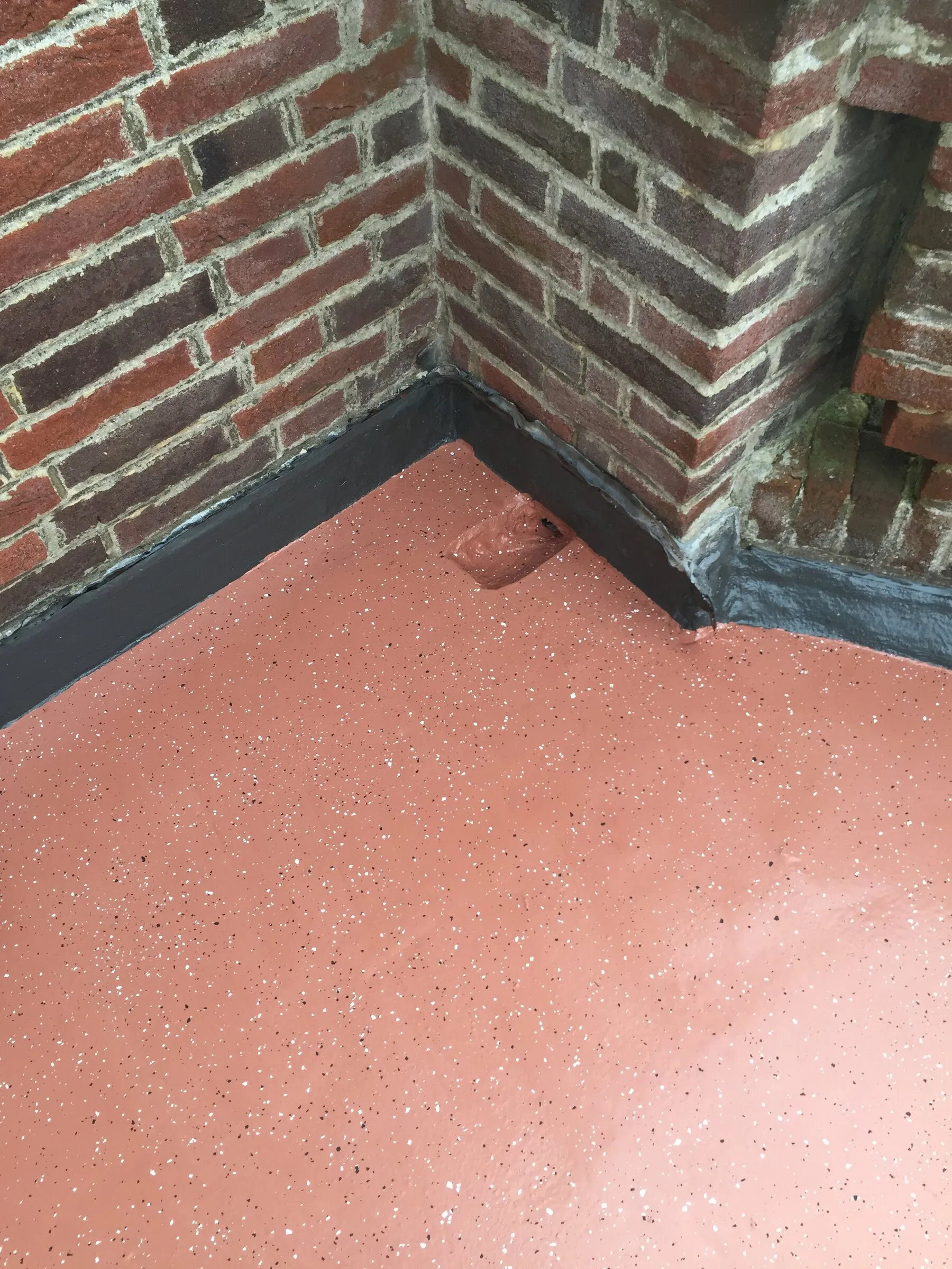 Close-up of red liquid resin dressed neatly into the corner of a brick wall