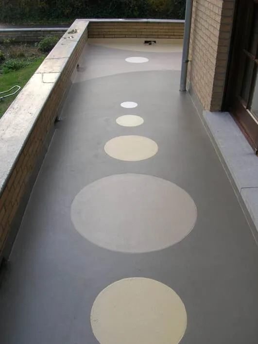 Grey resin walkway with a line of cream circles set into the finish